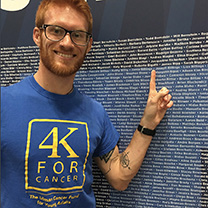 Matthew Billings at wall with names of NYC marathon runners