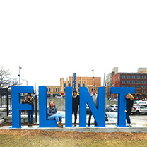 Students pose with Flint city sign