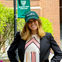 Melissa Shew wearing Air Products hat in front of College banner