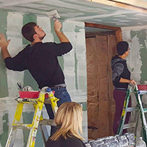 Students painting a ceiling during service project