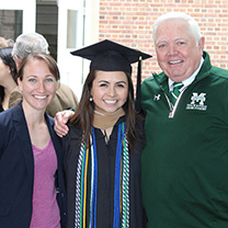 2018 graduate with coaches on quad